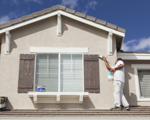 Busy House Painter Painting the Trim And Shutters of A Home.